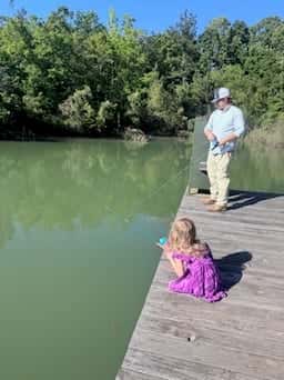 Child and adult casting a line from the dock