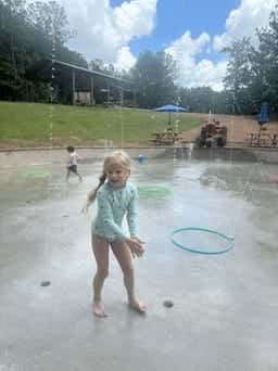 Girl playing with a hula hoop in the splash pad