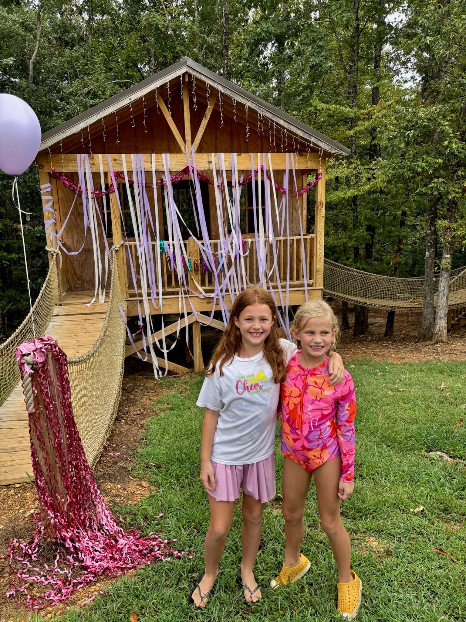 Two girls at the treehouse decorated with ribbons